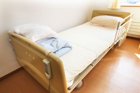 介護用ベッドが設置された個室。白いシーツと枕が整えられています。